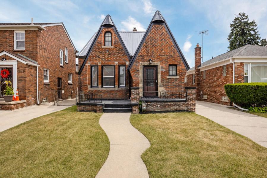 A brick Tudor-style rental home on a Detroit residential street.